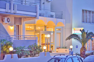 a building with cars parked in a parking lot at Falassarna Hotel in Chania Town