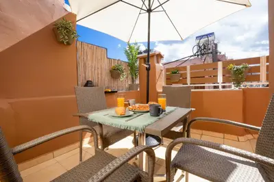 a table and chairs on a balcony with an umbrella at Suite Maritime in Chania Town