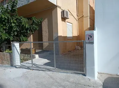 a gate in front of a building with a dog behind it at Casa.Costiera in Palaiochóra