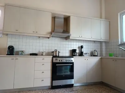 a kitchen with white cabinets and a black oven at Casa.Costiera in Palaiochóra
