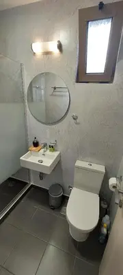 a bathroom with a white toilet and a sink at Casa.Costiera in Palaiochóra