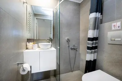 a bathroom with a shower and a toilet and a sink at Casa Maria 300 meters from the sea in Chania Town