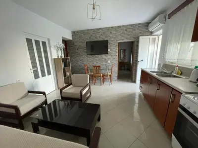 a kitchen and living room with a couch and a table at Claudia villa 2 in Agia Marina Nea Kydonias