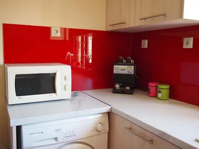 a kitchen with a white microwave and red walls at Charming apartment in Halepa! in Chania Town