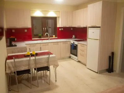 a kitchen with red walls and a table with chairs at Charming apartment in Halepa! in Chania Town