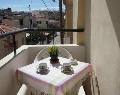 a table with cups and saucers on a balcony at Charming apartment in Halepa! in Chania Town