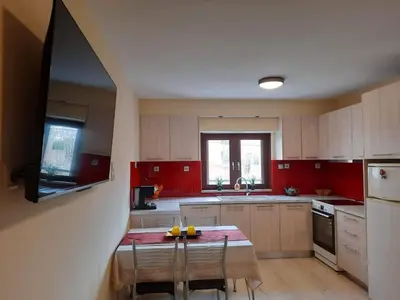 a kitchen with red cabinets and a table with chairs at Charming apartment in Halepa! in Chania Town