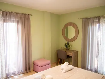 a bedroom with two beds and a desk and a mirror at Charming apartment in Halepa! in Chania Town