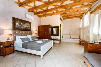 a large bedroom with a bed and a couch at Bozzali Deluxe Hotel in Chania Town