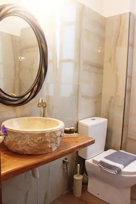 a bathroom with a sink and a toilet at Bozzali Deluxe Hotel in Chania Town
