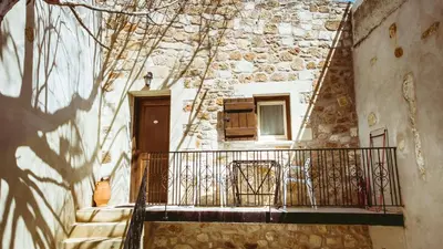 a stone building with a balcony and a window at Bozzali Deluxe Hotel in Chania Town