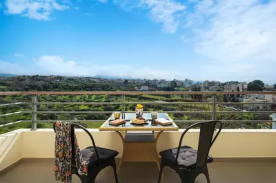 a table and chairs on a balcony with a view at Halepa Luxury Apartments in Chania Town
