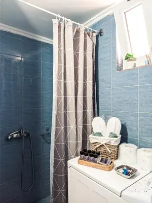 a bathroom with blue tiles and a shower curtain at Beautiful apartment in Chania in Chania Town