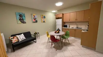 a kitchen and a living room with a table and chairs at Centro Apartment in Chania Town