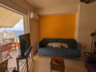 a living room with a blue couch and a balcony at Tamar's place in Chania Town