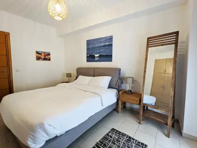a bedroom with a large bed and a mirror at Tamar's place in Chania Town