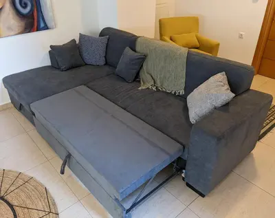 a blue couch with pillows on it in a living room at Tamar's place in Chania Town