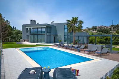 a swimming pool in front of a house at SeaSilia Luxury Villa in Korakiaí