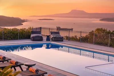 a swimming pool with a view of the water at SeaSilia Luxury Villa in Korakiaí