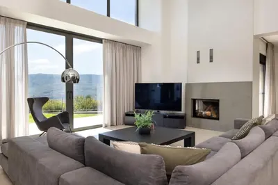 a living room with a large couch and a tv at SeaSilia Luxury Villa in Korakiaí