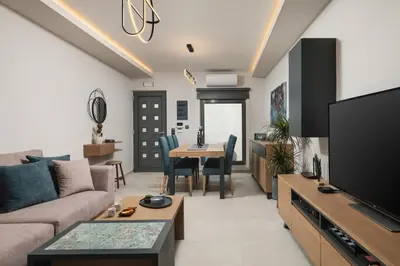 a living room with a couch and a tv and a table at 2 bd downtown home with private parking 400 meters walk to the beach in Chania Town