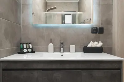 a bathroom with a sink and a mirror at 2 bd downtown home with private parking 400 meters walk to the beach in Chania Town