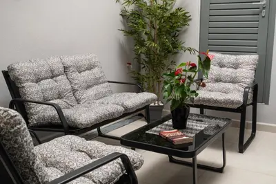 two chairs and a coffee table in a living room at 2 bd downtown home with private parking 400 meters walk to the beach in Chania Town