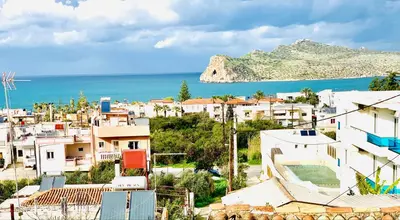 a city with houses and the ocean in the background at D&R Sunshine Apartment in Agia Marina Nea Kydonias