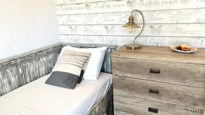 a bedroom with a bed with a lamp and a dresser at D&R Sunshine Apartment in Agia Marina Nea Kydonias