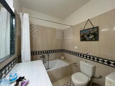 a bathroom with a toilet and a bath tub at Ammos Beachfront House by 8essentially in Kato Daratso