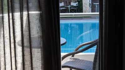 a view of a swimming pool from a window at Theros Hotel in Tavronitis