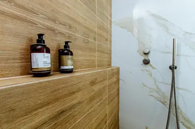 two bottles of wine sitting on a wooden shelf in a bathroom at Porfyra Suite 2 in Chania Town