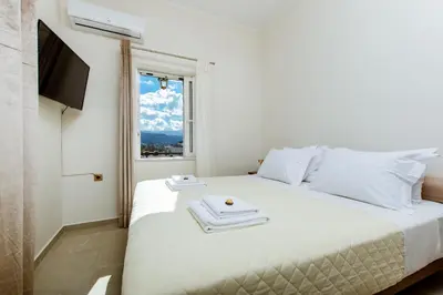 a bedroom with a white bed with towels on it at Porfyra Suite 2 in Chania Town