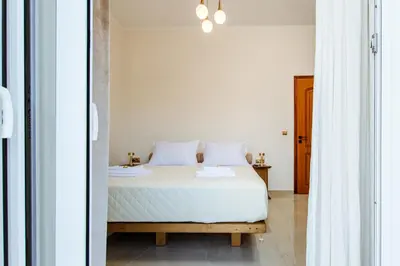 a bedroom with a bed with white sheets at Porfyra Suite 2 in Chania Town