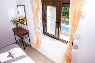a bedroom with a window and a bed and a table at Villa Vicina - In Platanias and 4min by the beach in Chania Town