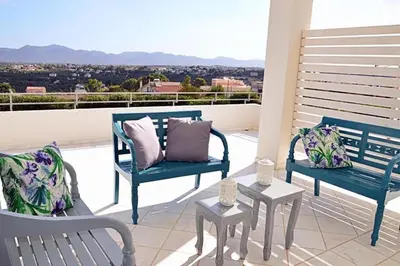 two blue benches sitting on a balcony with a view at Villa Sobre - Spacious and Comfortable. in Kounoupidhianá