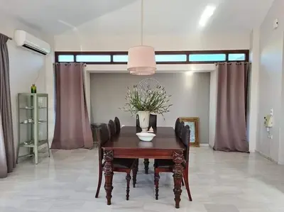 a dining room with a wooden table and chairs at Villa Sobre - Spacious and Comfortable. in Kounoupidhianá