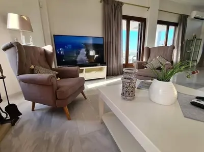 a living room with two chairs and a television at Villa Sobre - Spacious and Comfortable. in Kounoupidhianá