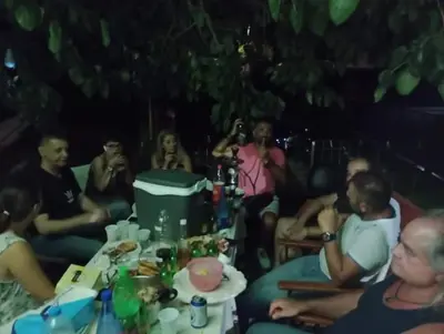 a group of people sitting around a table with drinks at Cornelia Hippie Magic Bus in Kissamos