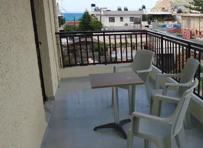 a table and chairs on a balcony with a view at ROMANTZA apartments in Agia Marina Nea Kydonias