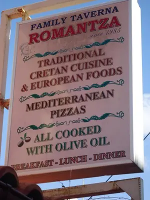a sign for a restaurant on the side of the road at ROMANTZA apartments in Agia Marina Nea Kydonias