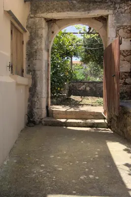 an archway in a stone building with an open door at Evanthea Residence in Kounoupidhianá