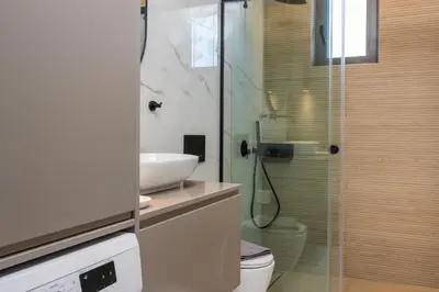 a bathroom with a shower and a toilet and a sink at Orama Luxury Apartments in Agia Marina Nea Kydonias