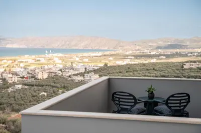 two chairs and a table on a balcony with a view at Emmanuel's Sea View Luxury Apartment in Kissamos