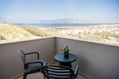 a table and chairs on a balcony with a view of the ocean at Emmanuel's Sea View Luxury Apartment in Kissamos