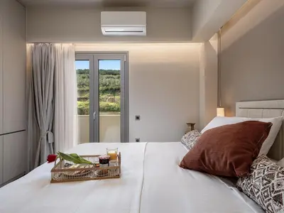a bedroom with a bed with a tray of food on it at Emmanuel's Sea View Luxury Apartment in Kissamos