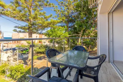 a patio with a table and chairs on a balcony at Beachfront villa Agia Marina in Stalos