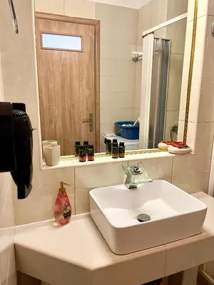 a bathroom with a white sink and a mirror at Beachfront villa Agia Marina in Stalos