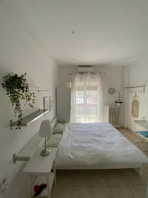 a white bedroom with a large bed and a window at maren apartment in Chania Town