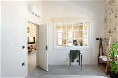 a white room with a chair and a window at PETRA - casa casa group in Chania Town